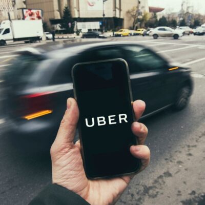 Aplikacja Uber wraz z taksówką w tle